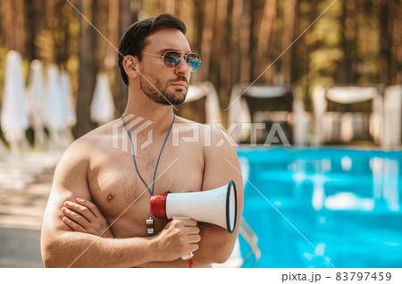 Male lifeguard in sunglasses near the public swimming pool Male lifeguard in sunglasses near the public swimming pool 83797459