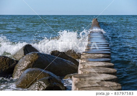 Waves crashing on breakwaters. Sea wave splashing. Waves and a storm at sea. Baltic Sea. 83797583