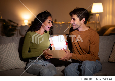 Husband Giving Christmas Gift To Wife, Opening Box Together Indoor 83798438