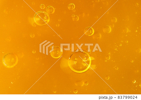 Texture of transparent yellow gel with air bubbles and waves on orange background. Concept of skin moisturizing, body care and prevention of covid19. Liquid beauty product closeup. Backdrop, flat lay Texture of transparent yellow gel with air bubbles and waves on orange background. Concept of skin moisturizing, body care and prevention of covid19. Liquid beauty product closeup. Backdrop, flat lay 83799024