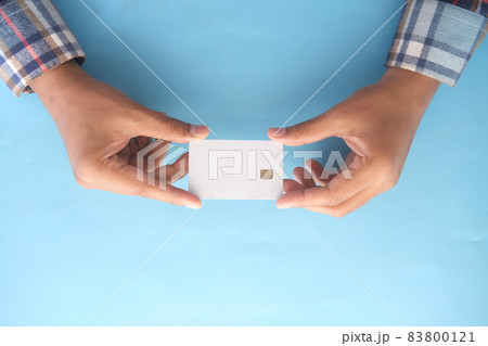 top view of hand hold a credit card on blue background  83800121