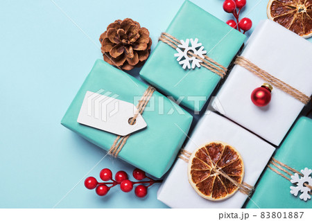 Gifts boxes packed in paper, decorated with baubles and twine. Eco Christmas Gift Wrapping Idea 83801887