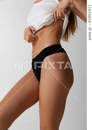 Cropped image of body of young slim woman isolated on gray studio background. Natural beauty concept. Side view Cropped image of body of young slim woman isolated on gray studio background. Natural beauty concept. Side view 83801911