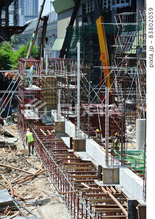 PERAK, MALAYSIA -APRIL 05, 2016: Construction workers wearing safety harness and installing scaffolding at high level in the construction site.  83802059