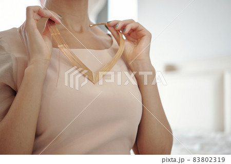 Woman Taking On Beautiful Necklace 83802319