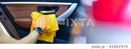 Male craftsman in gloves with microfiber wipes car handle of car closeup Male craftsman in gloves with microfiber wipes car handle of car closeup 83802979