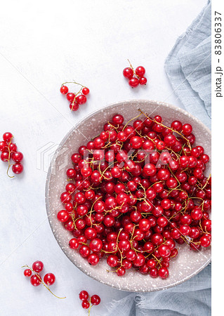 Fresh red currant in wooden bowl on grey table 83806337