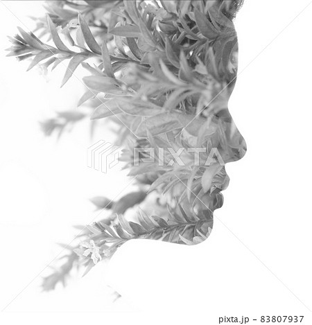 A black and white profile portrait of a woman combined with twigs in a double exposure technique 83807937