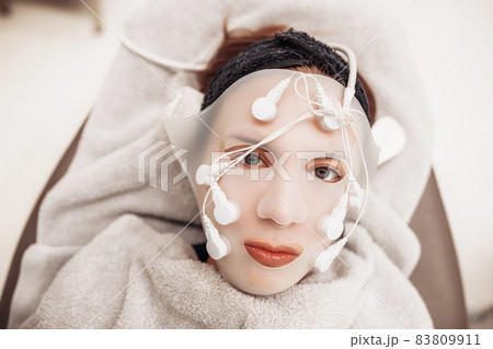 Woman receiving facial massage in beauty salon. 83809911