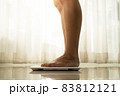 young woman standing on digital weight scale 83812121