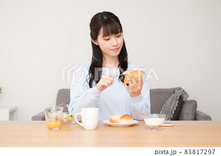 朝食のパンにバターを塗る女性 朝食のパンにバターを塗る女性 83817297