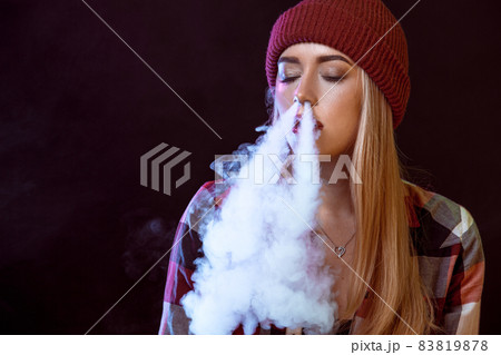 young woman smoking electronic cigarette 83819878