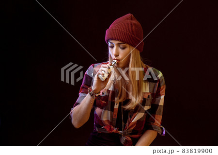young woman smoking electronic cigarette 83819900