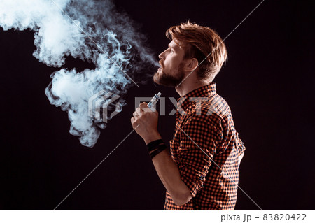 young man smoking electronic cigarette young man smoking electronic cigarette 83820422