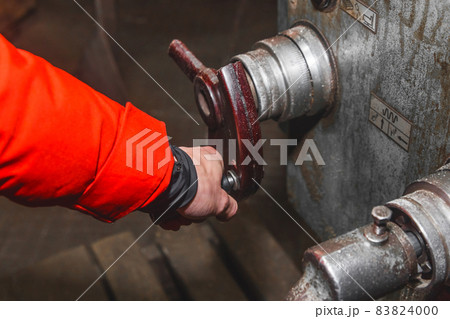 The hand of a working man in construction clothes holds the handle and controls the work of the milling machine in an industrial enterprise The hand of a working man in construction clothes holds the handle and controls the work of the milling machine in an industrial enterprise 83824000