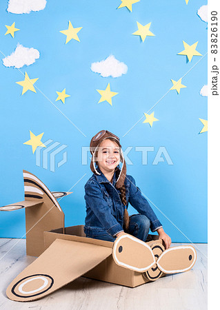 Little child girl in a pilot's costume is playing and dreaming of flying over the clouds. Little child girl in a pilot's costume is playing and dreaming of flying over the clouds. 83826190