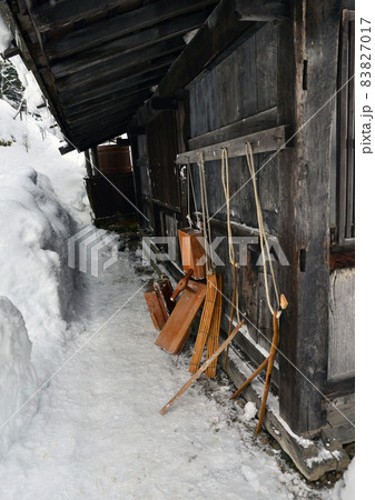 雪深い村の家の軒下に古いスキーやそりが立てかけてある 雪深い村の家の軒下に古いスキーやそりが立てかけてある 83827017