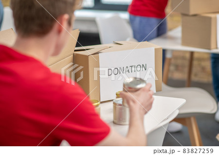 Volunteers in red thsirts taking part if donations distribution Volunteers in red thsirts taking part if donations distribution 83827259