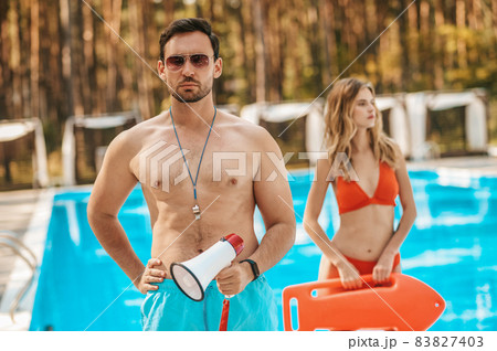 Two pool lifeguards standing near the public pool Two pool lifeguards standing near the public pool 83827403