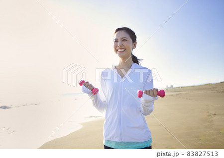 砂浜でウオーキングをするスポーツウエアの若い女性 砂浜でウオーキングをするスポーツウエアの若い女性 83827513