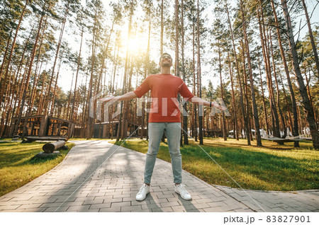 Man with his hands to sides standing in sun Man with his hands to sides standing in sun 83827901