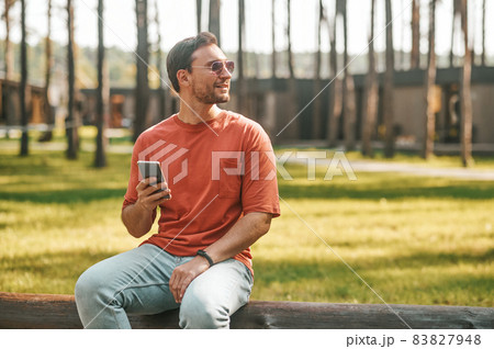 Man with smartphone looking to side Man with smartphone looking to side 83827948