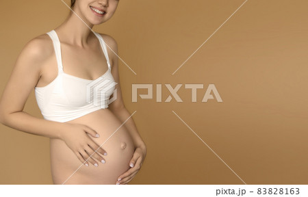 Beautiful pregnant young woman in clothes for 83828163