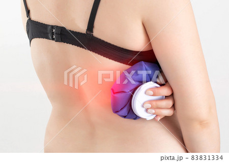 The girl holds a compress with a cold for pain of intercostal neuralgia, pinched nerve. Cold treatment of bruises and bruises, ligament rupture 83831334