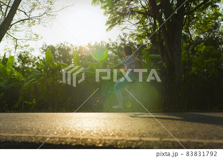 silhouette asian woman ride bicycle under tree in springtime 83831792