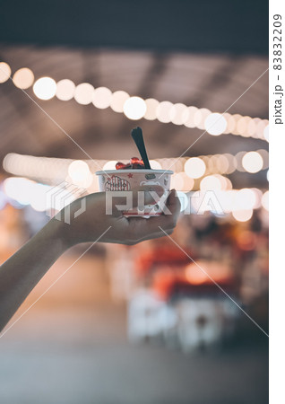 ice cream in human hand with bokeh of light 83832209
