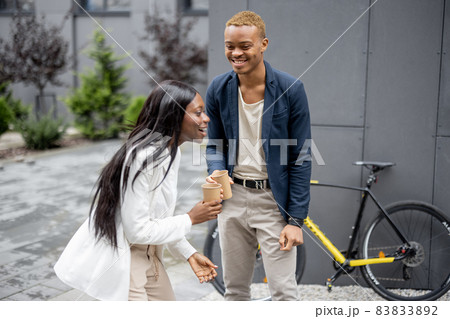 Business people talk and drink coffee outdoors Business people talk and drink coffee outdoors 83833892
