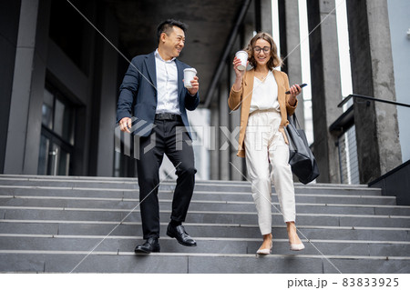Business people walking and talking in city Business people walking and talking in city 83833925