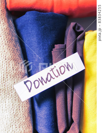 Clothes sorting in wardrobe for donation with paper note. 83834255