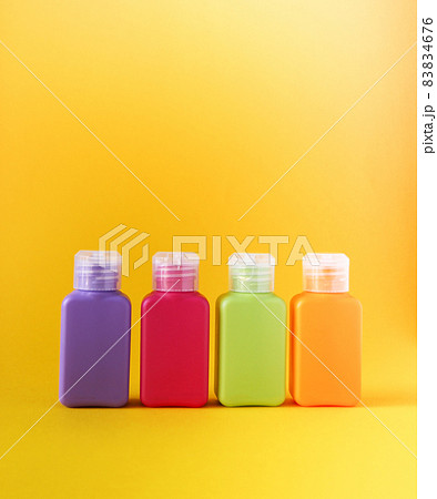 Colorful plastic bottles for skincare products or different purposes on yellow background Colorful plastic bottles for skincare products or different purposes on yellow background 83834676