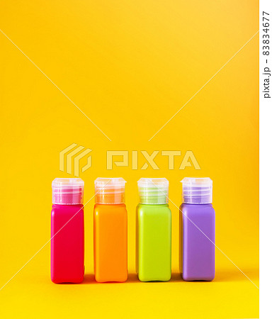 Colorful plastic bottles for skincare products or different purposes on yellow background Colorful plastic bottles for skincare products or different purposes on yellow background 83834677