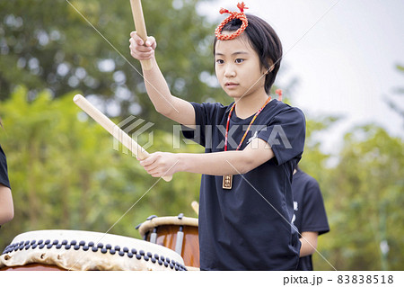真剣に和太鼓を演奏する小学生女の子 83838518