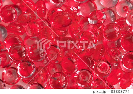 Transparent red glass marble beads. Acrylic ice stones for decoration. Water drops background. Abstract wallpaper or backdrop for web design 83838774