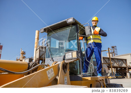 Cheerful male worker standing on industrial cabin 83839269