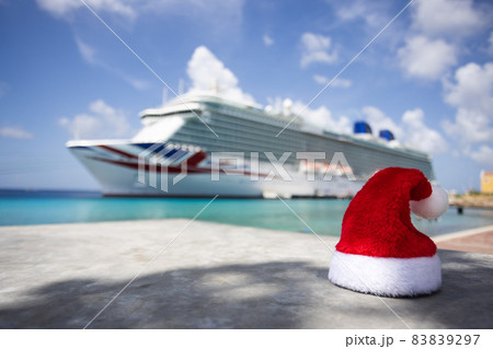 Santa hat Cruise ship staying in a harbour with turquoise colour sea. Selective focus. Santa hat Cruise ship staying in a harbour with turquoise colour sea. Selective focus. 83839297
