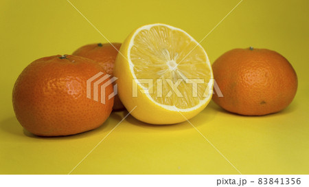 Sliced lemon and tangerine, on a yellow background. Citrus fruits. Sliced lemon and tangerine, on a yellow background. Citrus fruits. 83841356