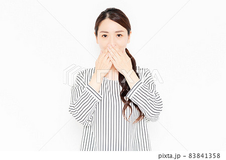 口を隠すカジュアルな服装の女性 口を隠すカジュアルな服装の女性 83841358