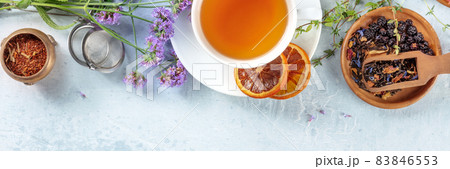 Tea panorama with a place for text, with a tea strainer, flowers, and herbs Tea panorama with a place for text, with a tea strainer, flowers, and herbs 83846553