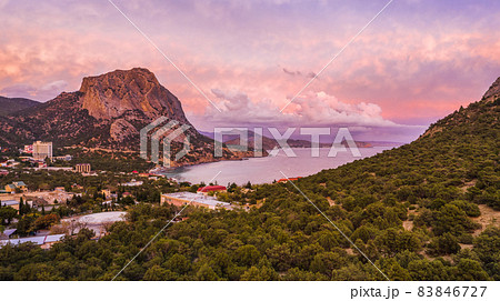 Aerial panoramic view of mount Falcon lit by pink sunset in Novyi Svit during autumn season. Sudak, the Republic of Crimea Aerial panoramic view of mount Falcon lit by pink sunset in Novyi Svit during autumn season. Sudak, the Republic of Crimea 83846727