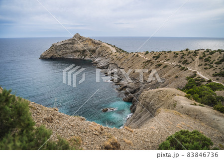 Cape Kapchik and Golitsyn trail at rocky Black Sea coast at sunny day, Novyi Svit, Sudak Municipality, Crimea Cape Kapchik and Golitsyn trail at rocky Black Sea coast at sunny day, Novyi Svit, Sudak Municipality, Crimea 83846736