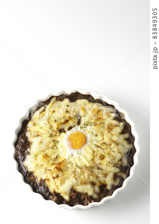 たっぷりのとろけるチーズと卵が乗った焼きカレーを白背景で俯瞰撮影 83849305