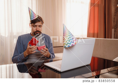 young man sitting at the table and talking by video call to friends. 83850558