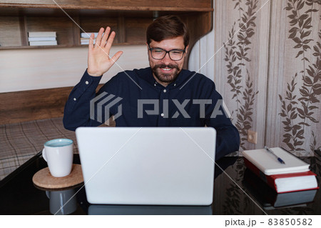 Focused man sitting at desk watching webinar video course Focused man sitting at desk watching webinar video course 83850582
