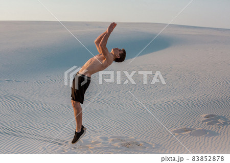 Man study parkour on their own. Acrobatics in the sand 83852878