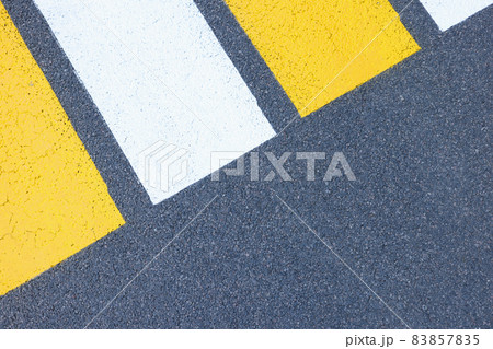Closeup of yellow and white stripes on gray asphalt background 83857835