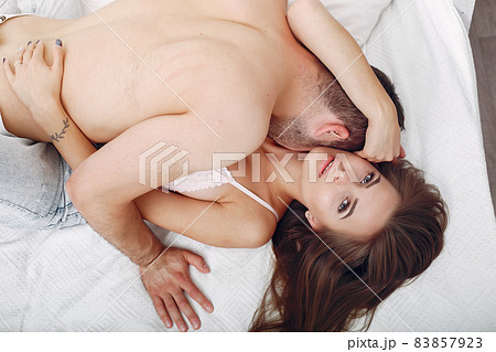 Couple lying on a bed in a room 83857923